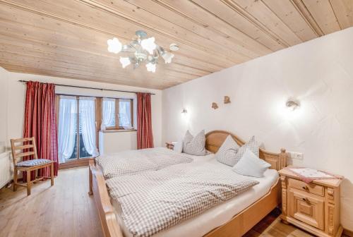 a bedroom with a bed and a wooden ceiling at Ferienwohnung Waxenstein in Grainau