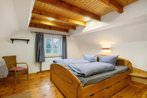 a bedroom with a wooden bed and a chair at Idyllisches Bauernhaus in Gerswalde