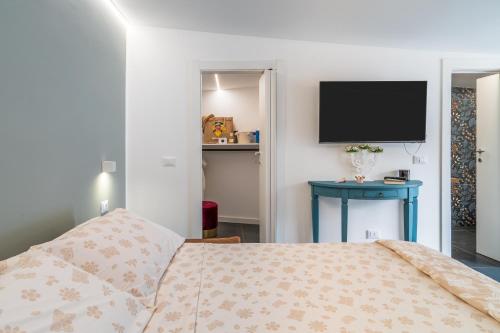 a bedroom with a bed and a flat screen tv at La casa di Susy in Avola