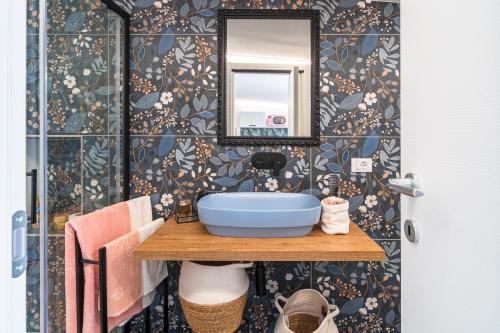 a bathroom with a blue sink and a mirror at La casa di Susy in Avola