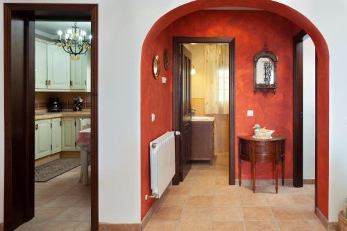 a kitchen with an archway leading to a kitchen with white cabinets at Casa La Mirada in Cómpeta