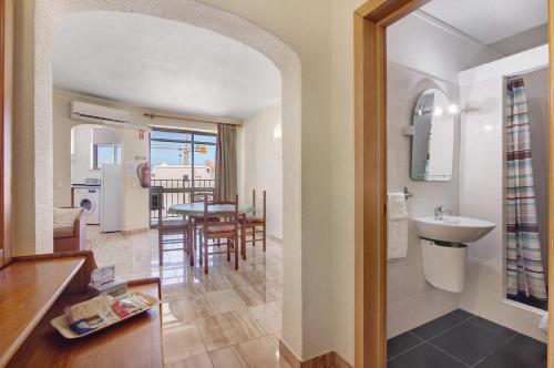 a kitchen and living room with a sink and a table at Casa Enxame in Armação de Pêra