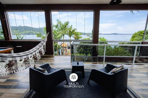a room with a hammock and a view of the water at Casa na Lagoa - Imaruí/SC in Imaruí