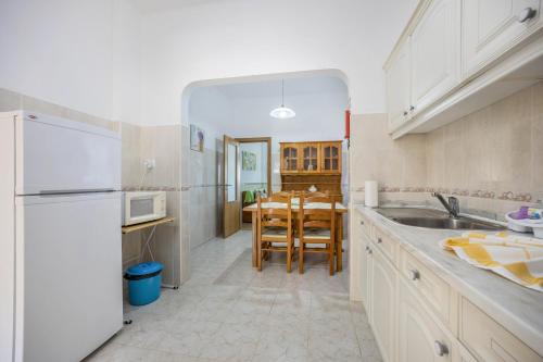 a kitchen with a white refrigerator and a table at Villas Brites nº2 in Burgau