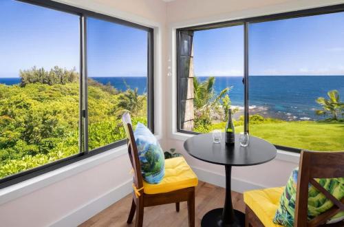 a dining room with a table and a view of the ocean at Sealodge A2 Romantic Ocean View Oasis with Pool in Princeville
