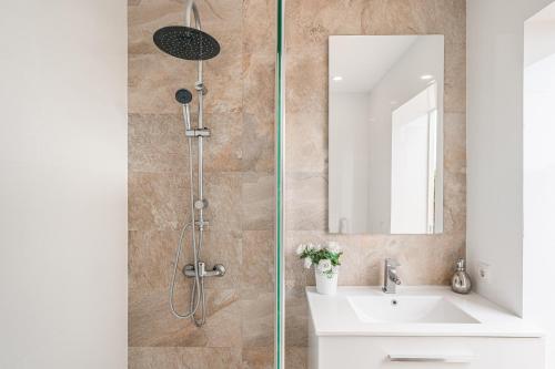 a bathroom with a shower with a sink and a mirror at Villa Sueños in Marratxí 