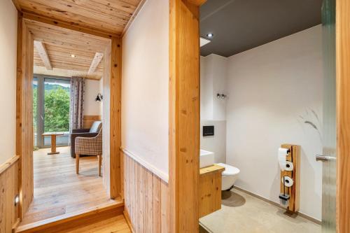 a bathroom with a toilet and wooden walls at Wein- und Klimahotel Bergfriedel in Bühlertal