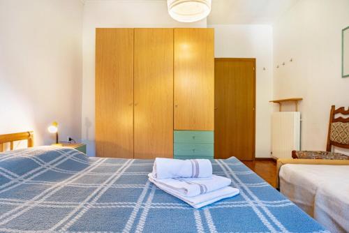 a bedroom with a blue bed with towels on it at Casa Ai Laresi 1 in Peio