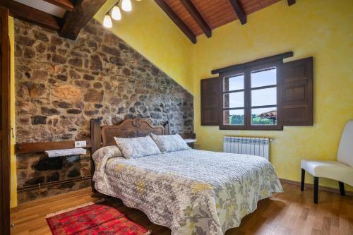 a bedroom with a bed and a stone wall at Pedregal in Gijón