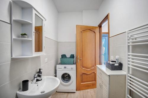 a bathroom with a washing machine and a sink at Cà du Mandaìn in Pairola