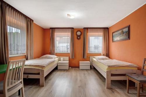 two beds in a room with orange walls at Haus Steinheim in Dillingen an der Donau