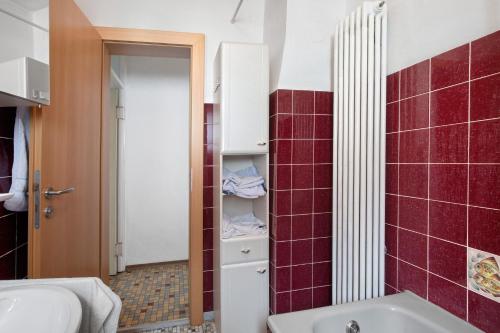 a bathroom with a tub and a sink and red tiles at Haus Steinheim in Dillingen an der Donau