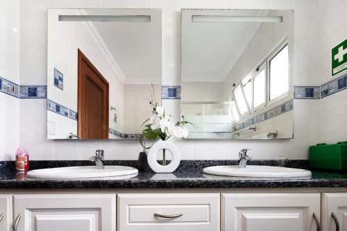 a bathroom with two sinks and a large mirror at Vivenda do Monte in Achadinha