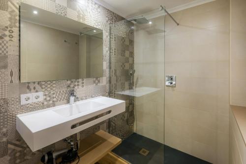 a bathroom with a sink and a glass shower at Apartament Massanet 2c in Canyamel