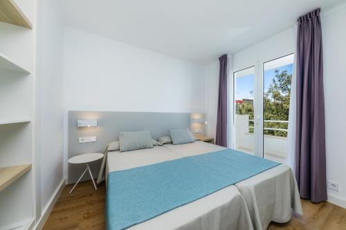 a bedroom with a bed and a large window at Apartament Massanet 2c in Canyamel