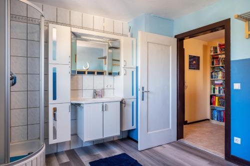 a small kitchen with white cabinets and a sink at Blackforest Ferienwohnung in Sankt Georgen im Schwarzwald