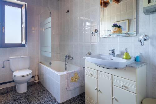 a bathroom with a toilet and a sink and a tub at Fuenternilla in Carranza