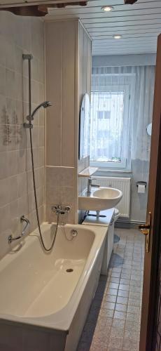 a bathroom with a bath tub and a sink at Ferienwohnung Mücheln 2 in Mücheln