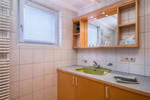 a bathroom with a sink and a mirror at Ferienhaus Villa Kanisblick in Bizau
