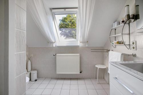 a white bathroom with a window and a sink at Ferienwohnung Marita Carstensen in Viöl