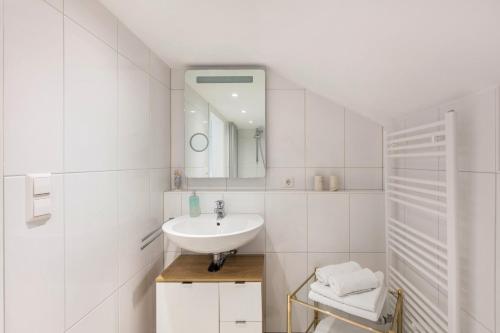 a white bathroom with a sink and a mirror at Ferienwohnung Haus Oehlberg in Todtmoos