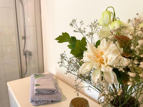 a bathroom with a vase of flowers on a counter at Ferienwohnung Grüner Ausblick in Elzach