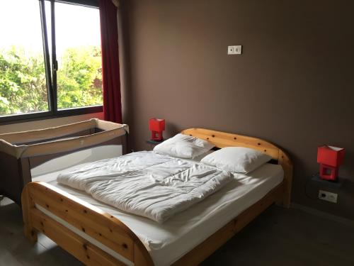 a bedroom with a wooden bed with a large window at Hâvre de Paix Perros in Perros-Guirec