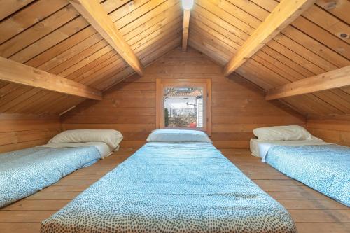 three beds in a room with wooden ceilings at Falaguera Barraca 3 in Bárig