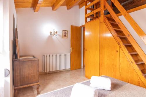 a living room with a wooden staircase and a stair case at Casa Batlle Ginebro in Les Iglésies