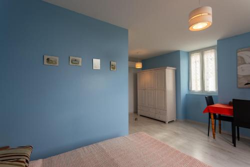 a bedroom with blue walls and a red table and a bed at Chambre d'hôtes Ticounat in Piets-Plasence-Moustrou