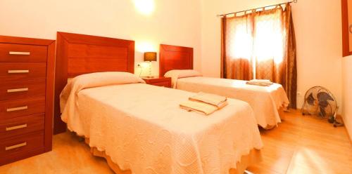 a bedroom with two beds and a dresser at Can Olivaret in Campos