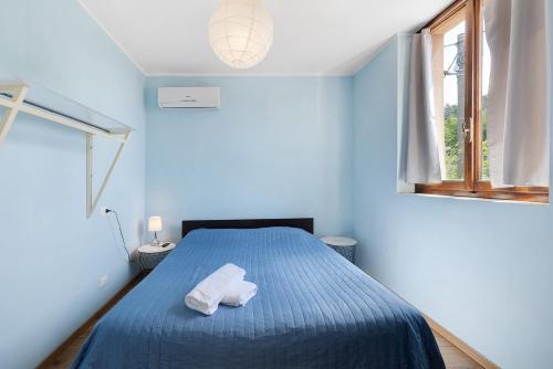 a blue bedroom with a bed with two towels on it at Casabianca - The best for bikers in Finale Ligure