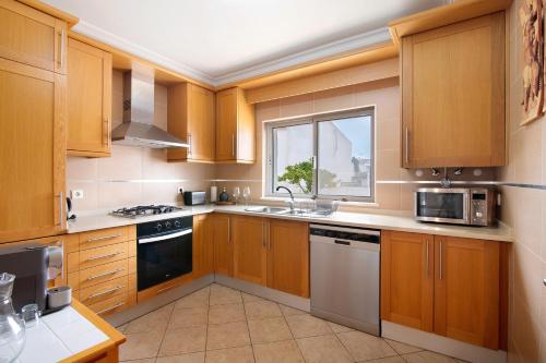 a kitchen with wooden cabinets and a window at Villa Essence of Grey in Manta Rota