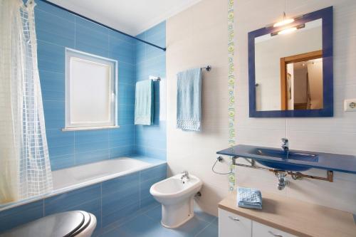 a blue bathroom with a toilet and a sink at Villa Essence of Grey in Manta Rota