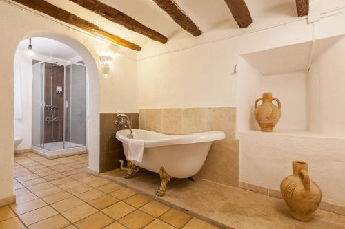 a bathroom with a bath tub in a room at Masía Can Trabal in Olerdola