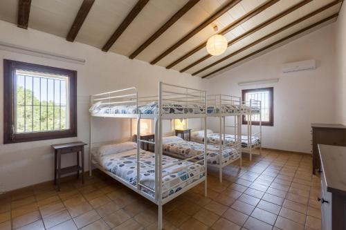 a room with three bunk beds in it at Masía Can Trabal in Olerdola
