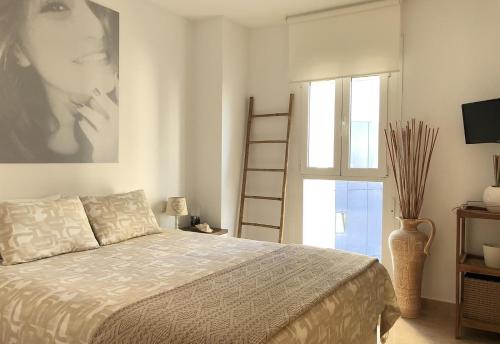 a bedroom with a bed and a picture of a woman at Front Line on the beach in Calpe