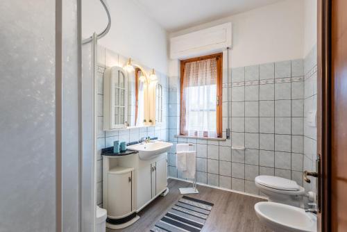 a white bathroom with a sink and a toilet at Agriturismo Osea in Monteriggioni