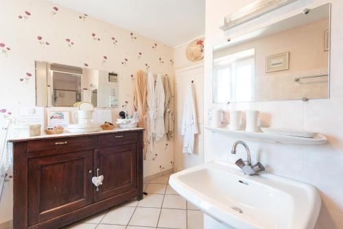 a bathroom with a sink and a tub and a mirror at Gite Bellevue Accous in Accous