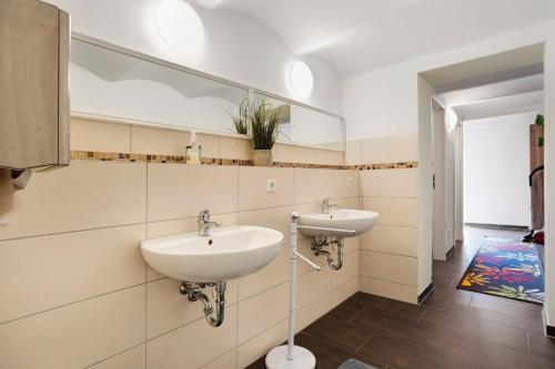 a bathroom with two sinks and a large mirror at Peenecamp Neukalen, Campingplatz in Neukalen