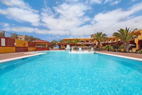 a large blue swimming pool with palm trees and buildings at Casa Anpi in Costa de Antigua