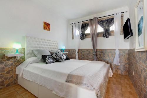 a bedroom with a white bed with pillows on it at Casa Anpi in Costa de Antigua