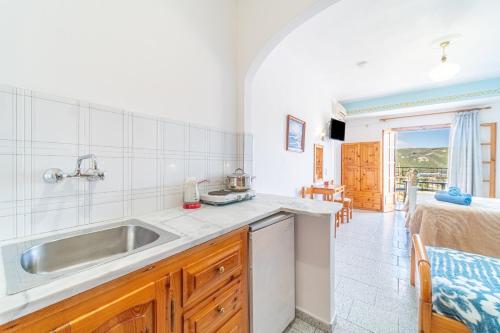 a kitchen with a sink and a room with a bed at Captain Spiros Studios in Paleokastritsa