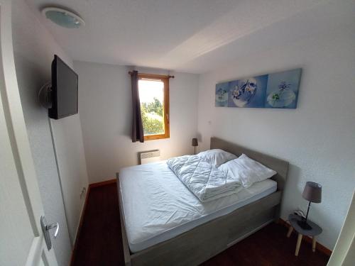 a small bedroom with a bed and a window at Appartement Le Maevan in Vassivière