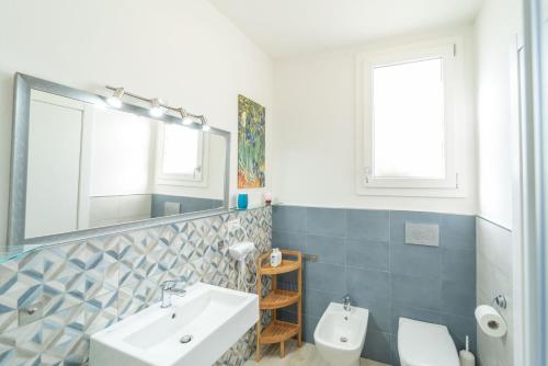a bathroom with a sink and a toilet and a mirror at Capriccio Mediterraneo in Sassari