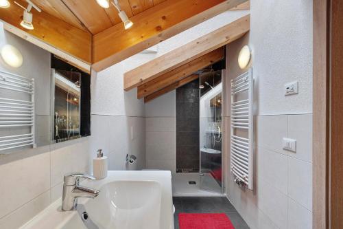 a bathroom with a sink and a bath tub at Ciasa Irene App Mansarde in La Villa