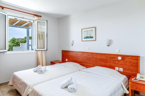 a bedroom with two beds and a window at Anemologio 302 Tinos in Agios Ioannis