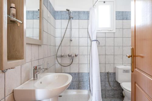 a bathroom with a sink and a shower at Anemologio 302 Tinos in Agios Ioannis