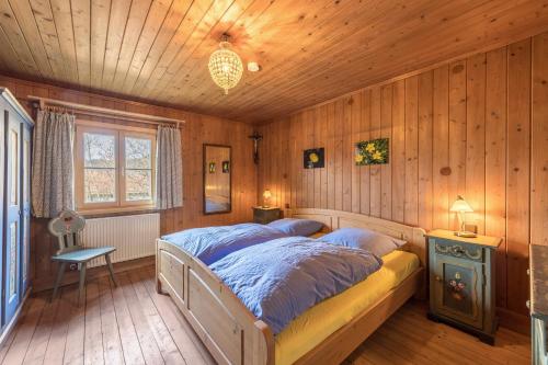 a bedroom with a bed in a room with wooden walls at Haus Löweneck in Bayrischzell