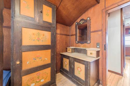 a bathroom with a sink and a wooden door at Haus Löweneck in Bayrischzell